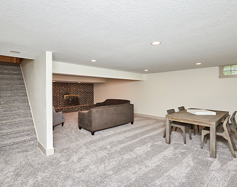 basement with living area and table with brick fireplace